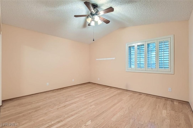 spare room with a textured ceiling, ceiling fan, vaulted ceiling, and light wood-type flooring