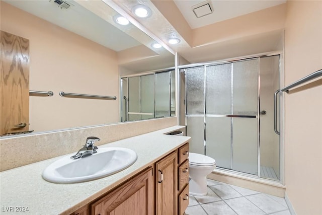 bathroom featuring tile patterned flooring, vanity, an enclosed shower, and toilet