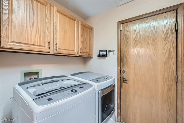 laundry room featuring washer and dryer and cabinets