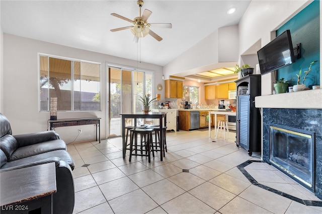 tiled living room with ceiling fan, a premium fireplace, and lofted ceiling