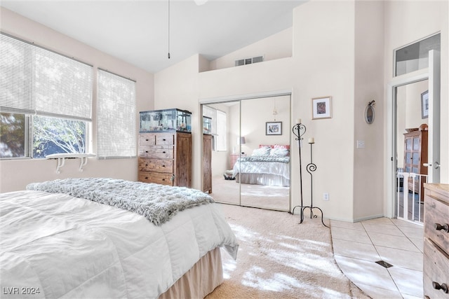 carpeted bedroom featuring a closet and high vaulted ceiling