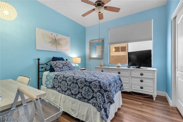 bedroom with dark hardwood / wood-style flooring and ceiling fan