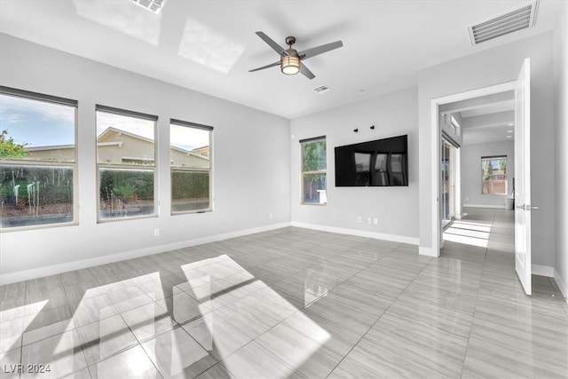 unfurnished living room with a wealth of natural light and ceiling fan