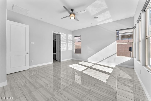 empty room with a wealth of natural light and ceiling fan