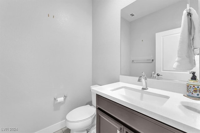 bathroom featuring tile patterned flooring, vanity, and toilet