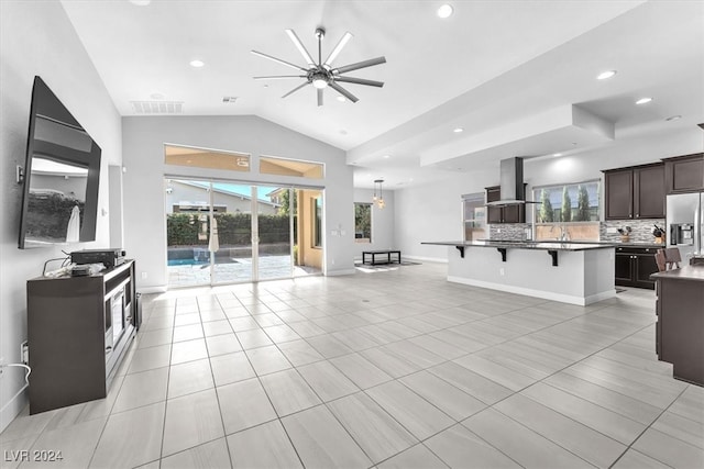 tiled living room with ceiling fan and vaulted ceiling