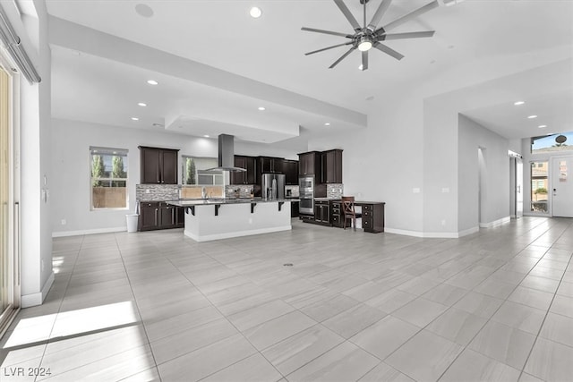 tiled living room with ceiling fan and sink