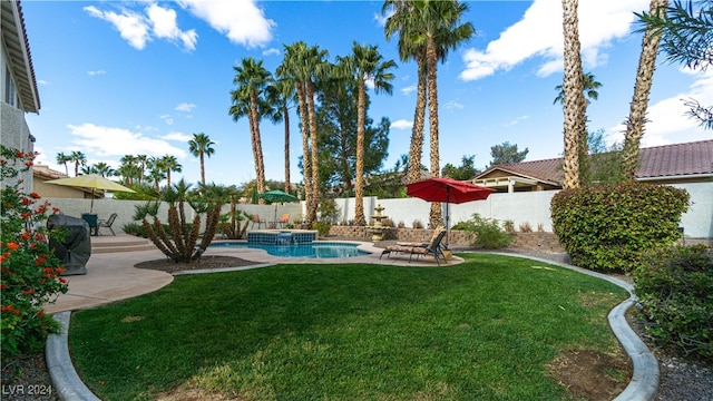 view of swimming pool featuring a lawn, a patio area, and an in ground hot tub