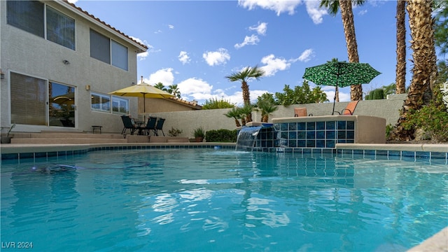 view of swimming pool with pool water feature