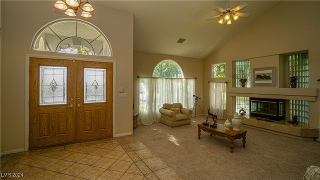 foyer entrance with plenty of natural light, light colored carpet, high vaulted ceiling, and french doors