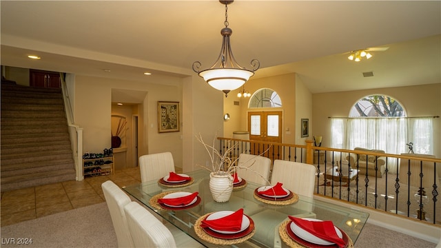 dining space with french doors, carpet, and a notable chandelier