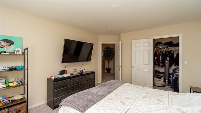 bedroom with a walk in closet, light colored carpet, and a closet