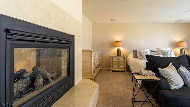 carpeted bedroom with a tile fireplace