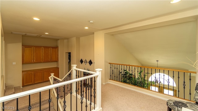 hall with light carpet and vaulted ceiling