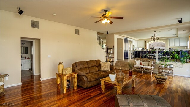 living room with hardwood / wood-style flooring and ceiling fan with notable chandelier