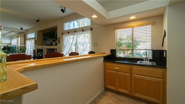 kitchen featuring kitchen peninsula, sink, and light tile patterned floors