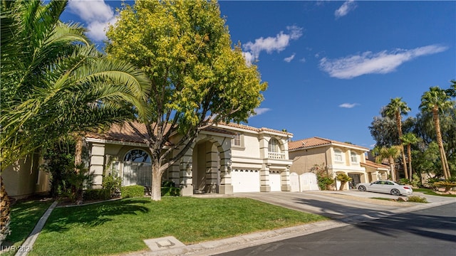 mediterranean / spanish home featuring a front yard and a garage