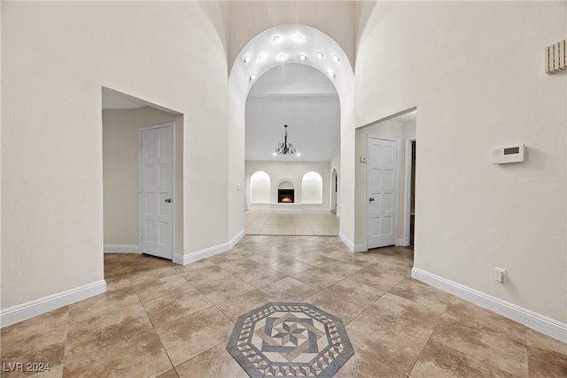 hallway featuring light tile patterned floors and a high ceiling