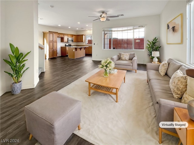 living room featuring ceiling fan and dark wood-type flooring