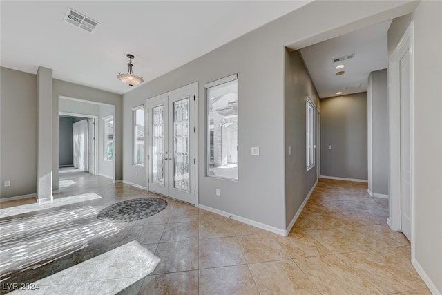 foyer entrance featuring french doors and light tile patterned flooring