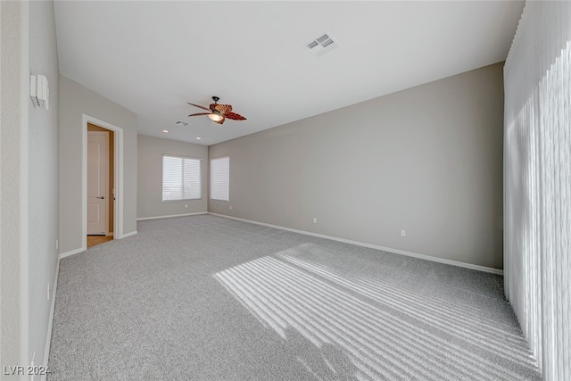 carpeted spare room featuring ceiling fan