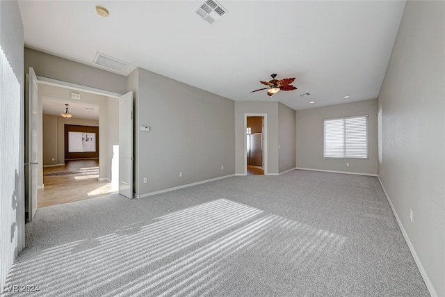 carpeted spare room with ceiling fan