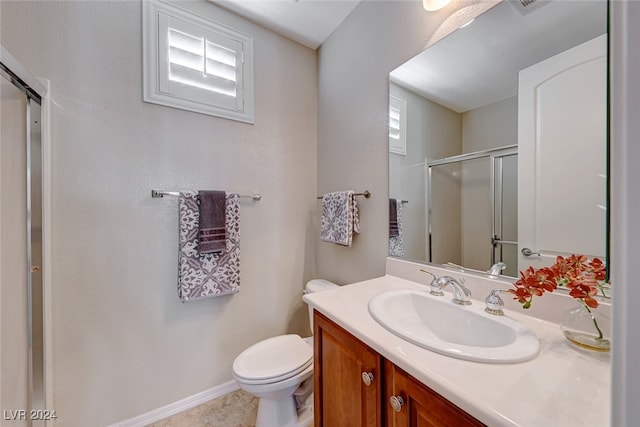 bathroom featuring tile patterned floors, vanity, toilet, and an enclosed shower