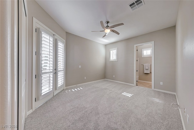 unfurnished room with light colored carpet and ceiling fan