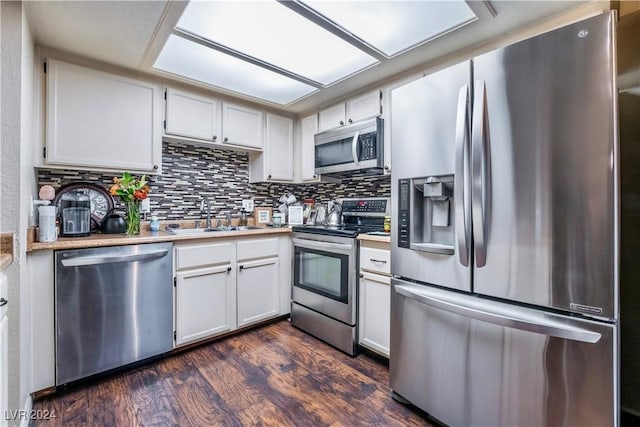 kitchen featuring sink, stainless steel appliances, dark hardwood / wood-style flooring, backsplash, and white cabinets