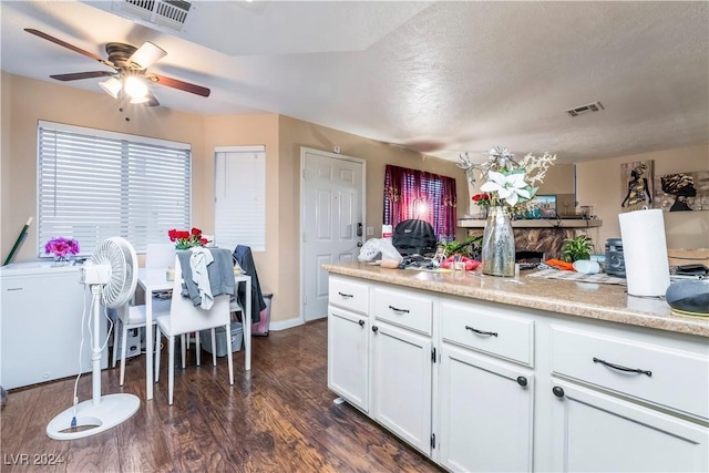 kitchen featuring white cabinets, a textured ceiling, dark hardwood / wood-style floors, and ceiling fan