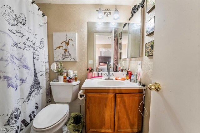 bathroom featuring vanity, toilet, and curtained shower