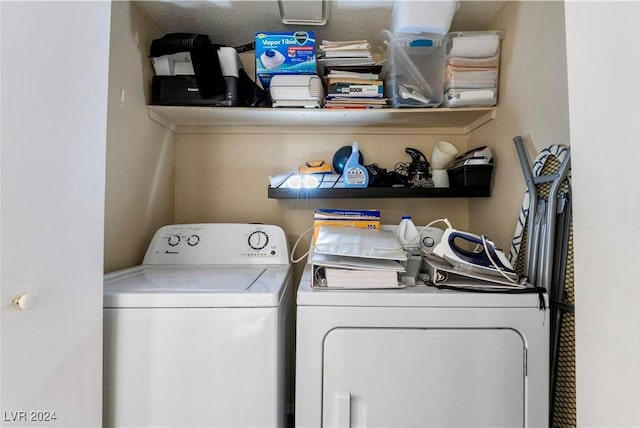 clothes washing area featuring a textured ceiling and washing machine and clothes dryer