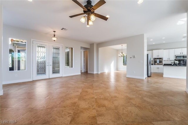 unfurnished living room with french doors and ceiling fan with notable chandelier