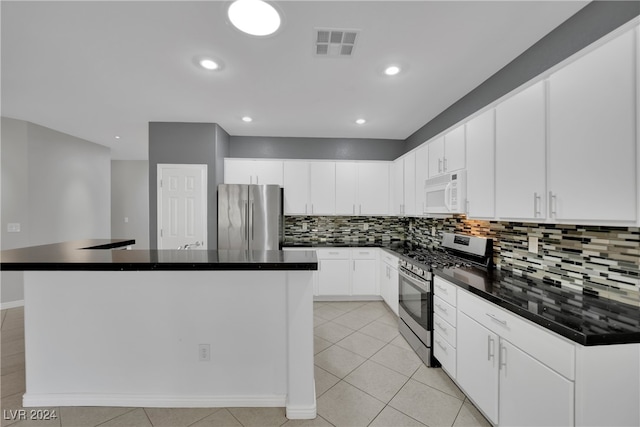 kitchen featuring backsplash, stainless steel appliances, light tile patterned floors, white cabinets, and a kitchen island