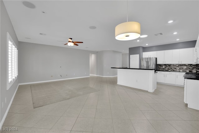 kitchen featuring stainless steel refrigerator, ceiling fan, backsplash, decorative light fixtures, and white cabinets