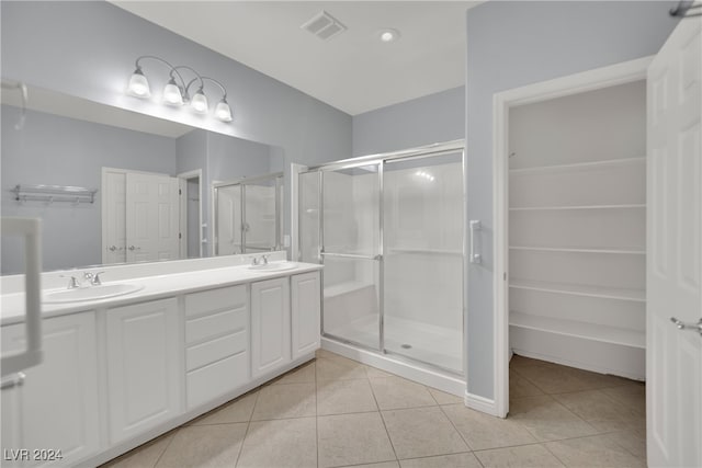 bathroom with tile patterned floors, vanity, and a shower with door