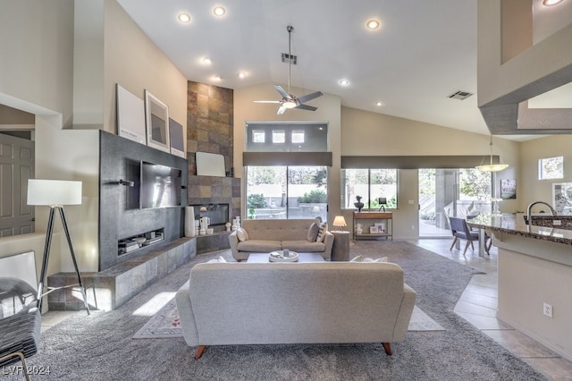 tiled living room featuring a tiled fireplace, ceiling fan, and high vaulted ceiling