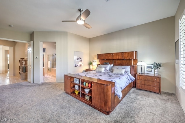 carpeted bedroom featuring ceiling fan and ensuite bathroom