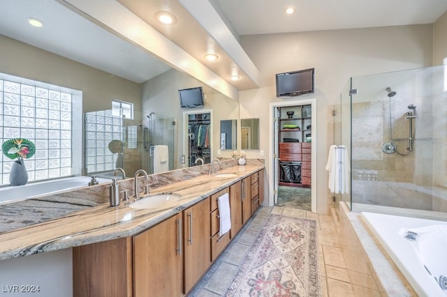 bathroom with tile patterned floors, vanity, and shower with separate bathtub