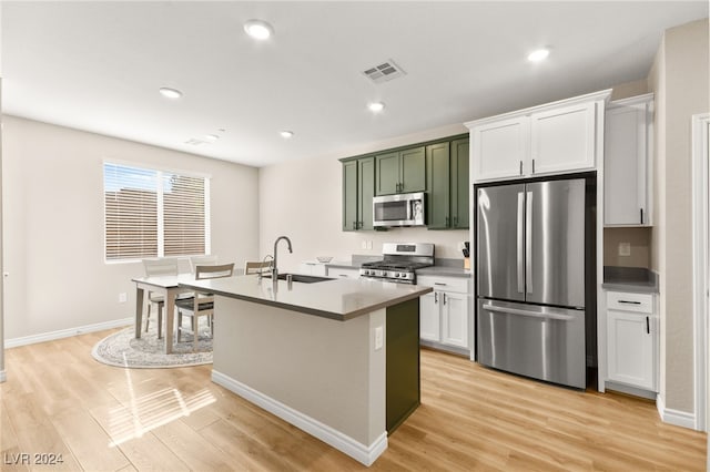 kitchen with appliances with stainless steel finishes, light hardwood / wood-style flooring, white cabinetry, and sink