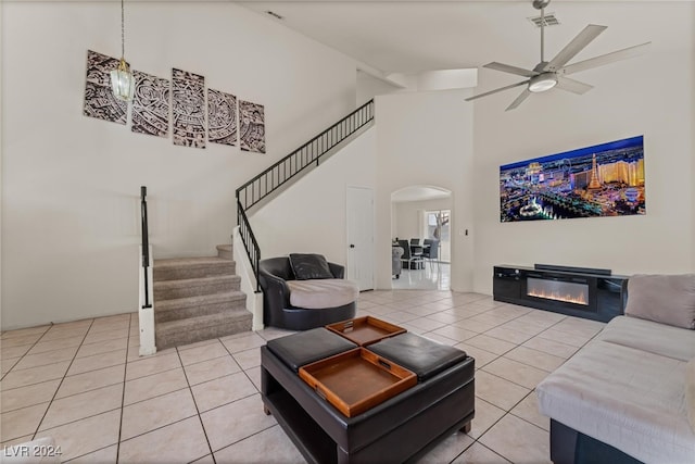 tiled living room featuring ceiling fan and high vaulted ceiling