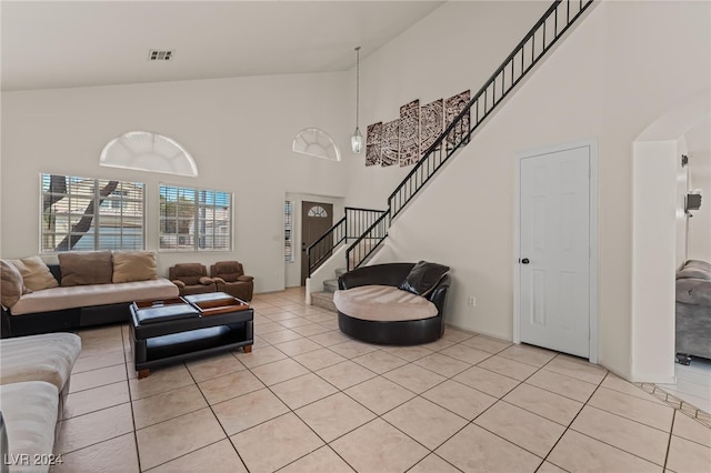 tiled living room with high vaulted ceiling and a chandelier