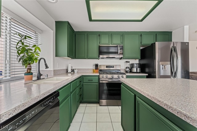 kitchen with light tile patterned flooring, stainless steel appliances, green cabinetry, and sink