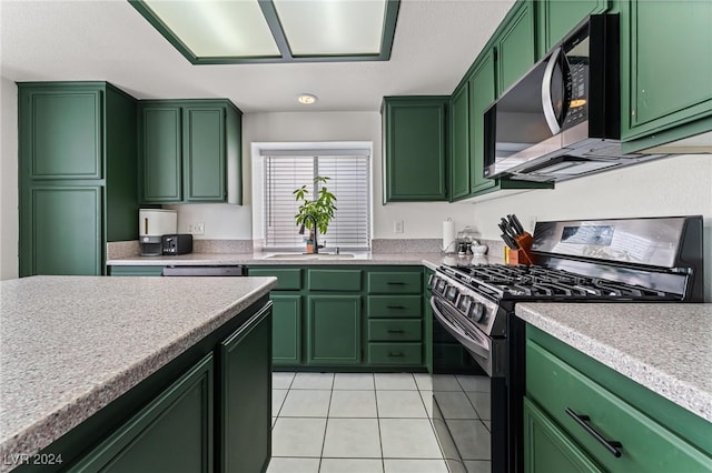 kitchen with black range with gas stovetop, light tile patterned floors, green cabinets, and sink