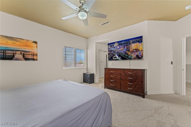 bedroom featuring ceiling fan, light colored carpet, and a closet