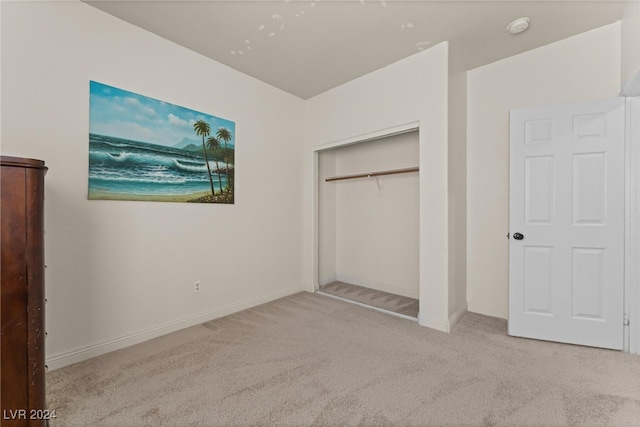 unfurnished bedroom with light carpet and a closet