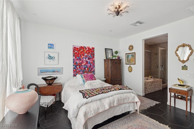 bedroom with connected bathroom and dark tile patterned flooring