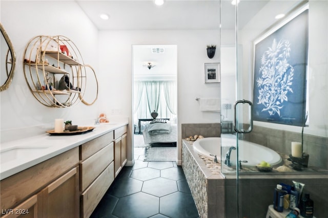 bathroom with vanity, tile patterned floors, and tiled tub