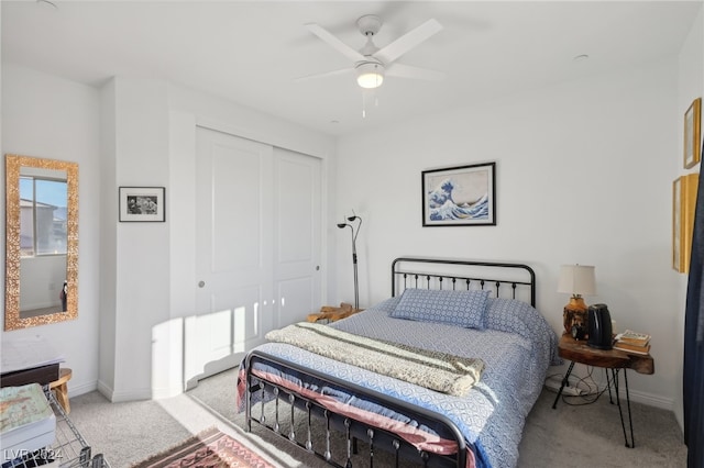 bedroom with ceiling fan, light colored carpet, and a closet