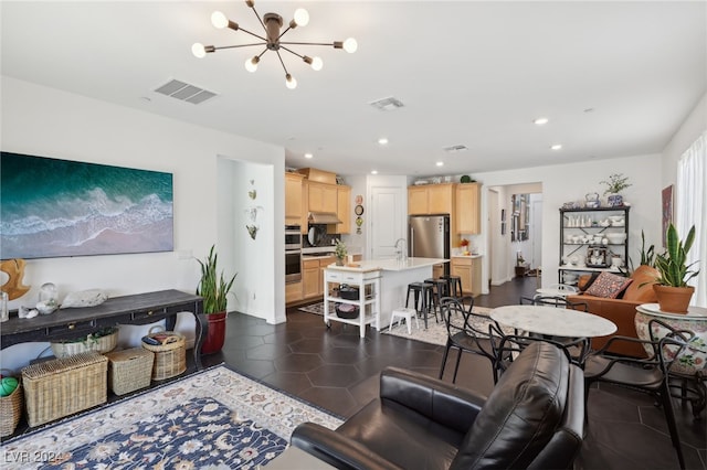 living room with sink, dark tile patterned flooring, and a notable chandelier